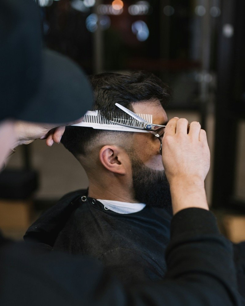 Corte de pelo con tijera y peine en un local